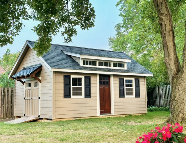 Tan shed with gray roof and brown door